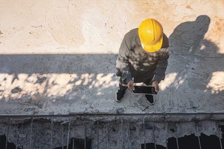 Concrete Worker Salary Guide: Concrete worker checking notifications on a tablet