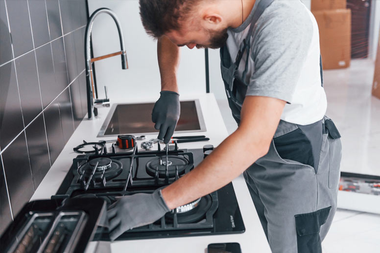 How Much Does Appliance Repair Cost: man fixing the kitchen