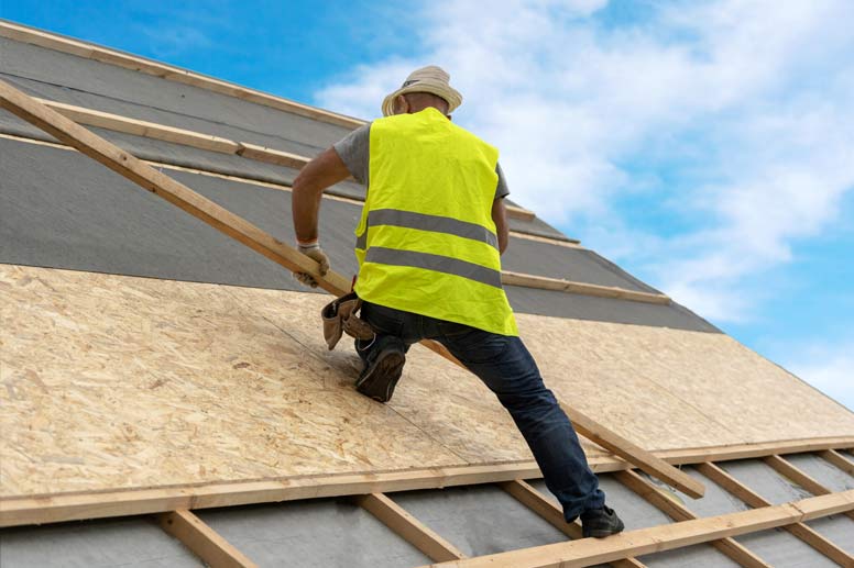 How To Get Your Roofing Insurance: Roofing Worker Placing Wood Planks