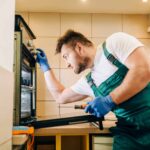 How To Get An Appliance Repair Business Insurance: Man Repairing Oven