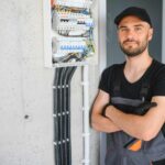 How To Get An Electrical License: Electrician Posing With Electrical Panel