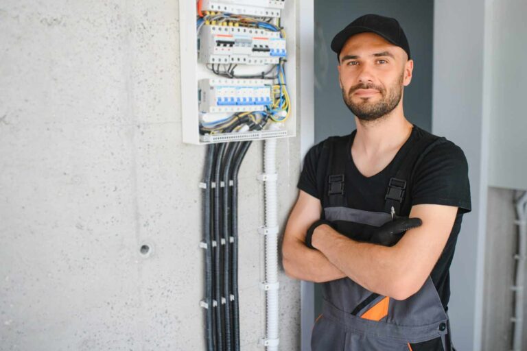 How To Get An Electrical License: Electrician Posing With Electrical Panel