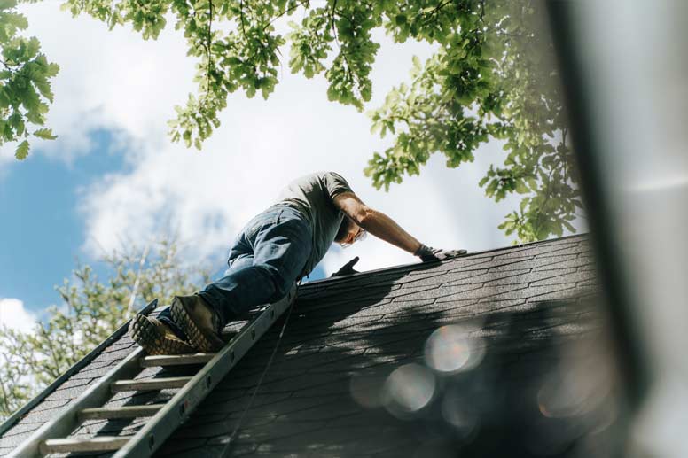 Roofer Salary Guide 2024 - Roofer Worker Climbing Roof