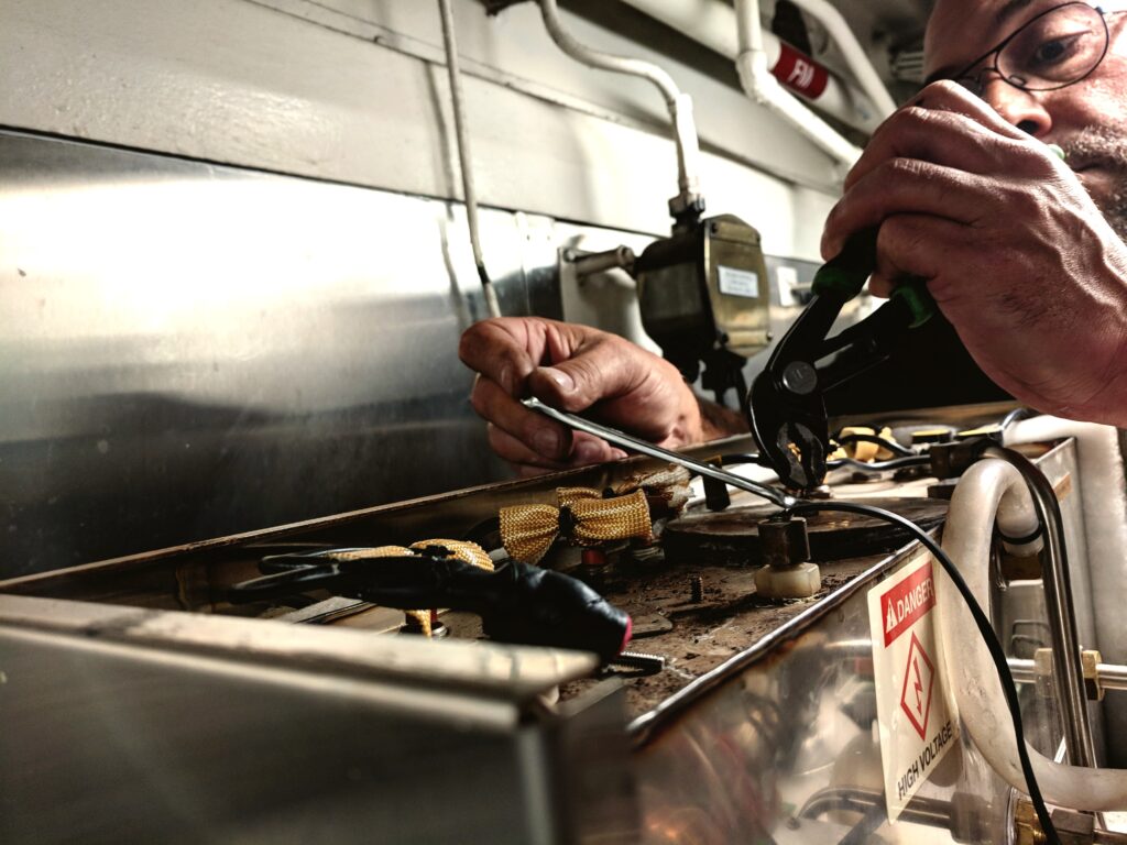 Senior appliance repair technician working on difficult electric appliance.