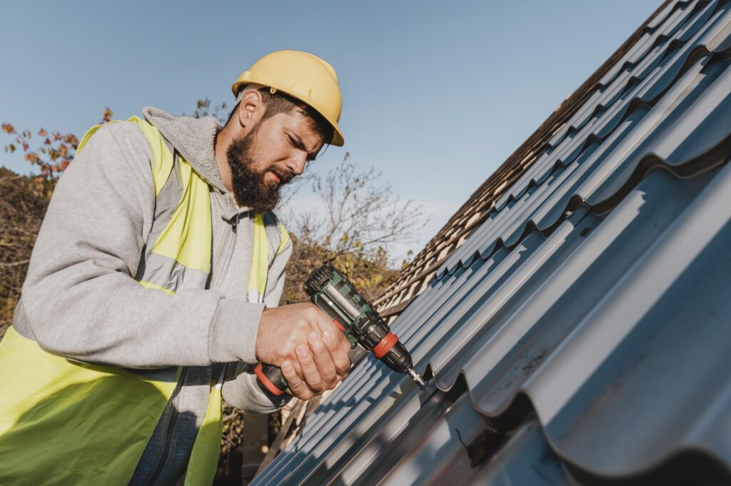Roofing worker sideways nailing roof tiles