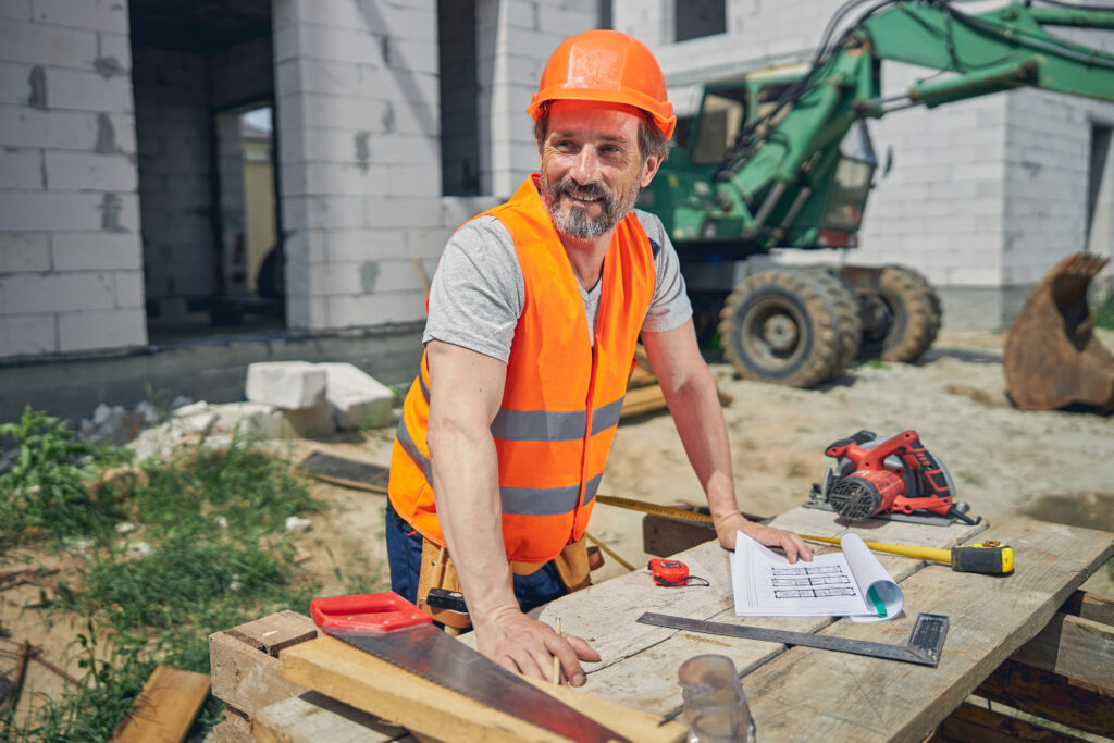 Civil engineer leaning his hands on a wooden table at a building site
