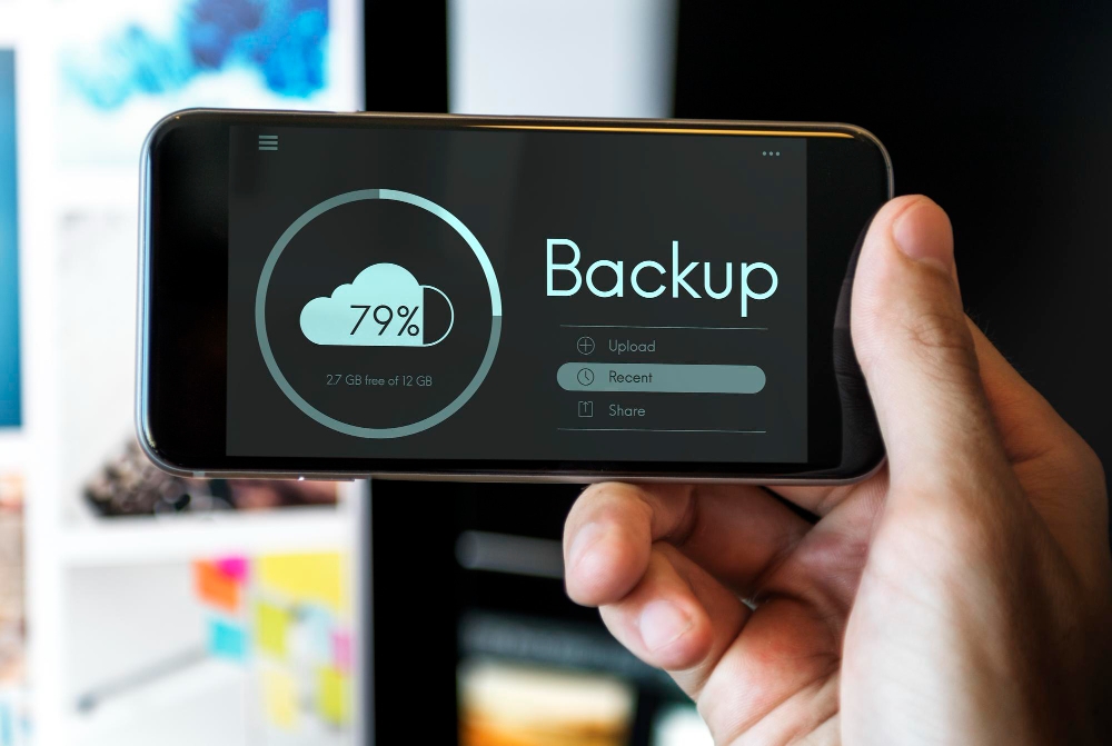 Data backup and sync process on mobile phone connected to laptop.