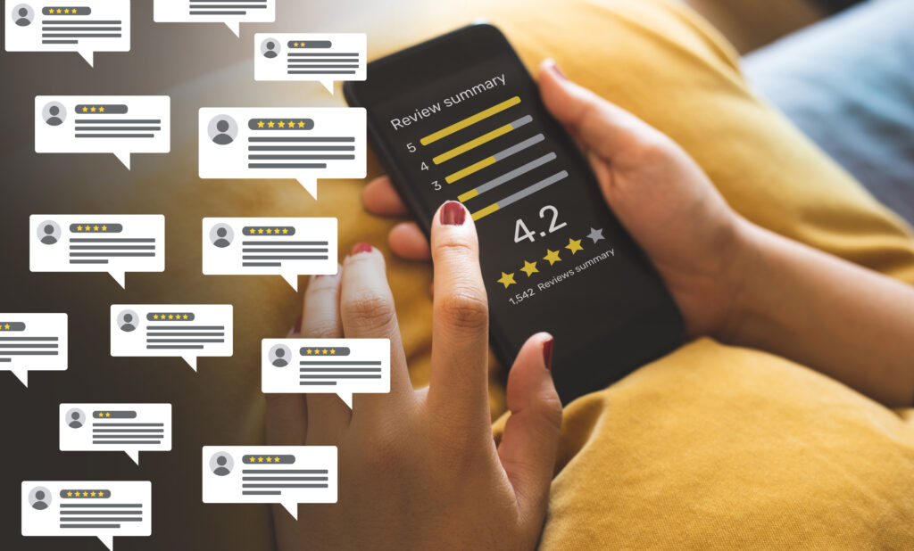 Person checking a 4.2-star review summary on a smartphone with multiple customer feedback icons around.