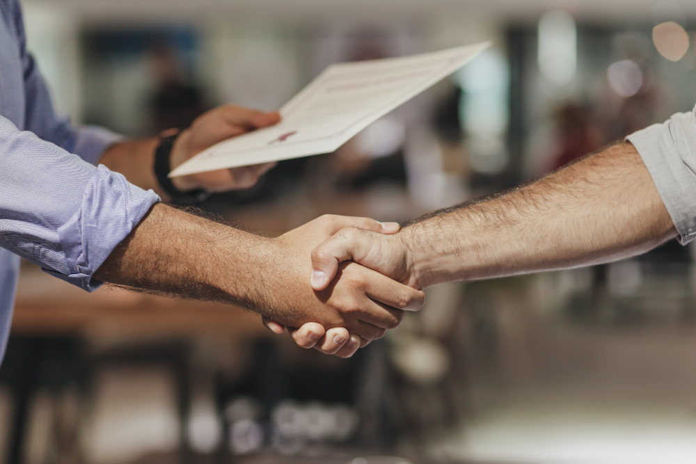 Two business partners shaking hands in agreement on partnership structure.
