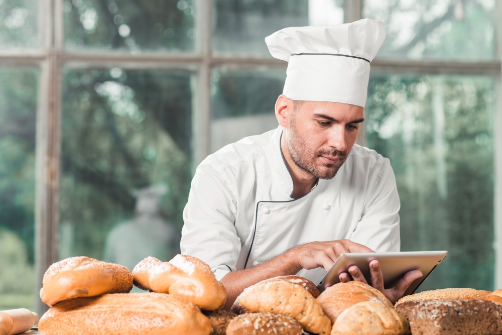 Bakery owner conducting running survey on laptop