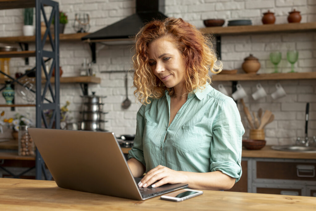 Small business owner conducting market research using a laptop and survey tools