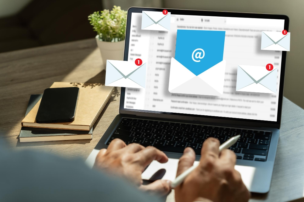 Laptop with email icons floating above the screen, representing HVAC email marketing strategies.