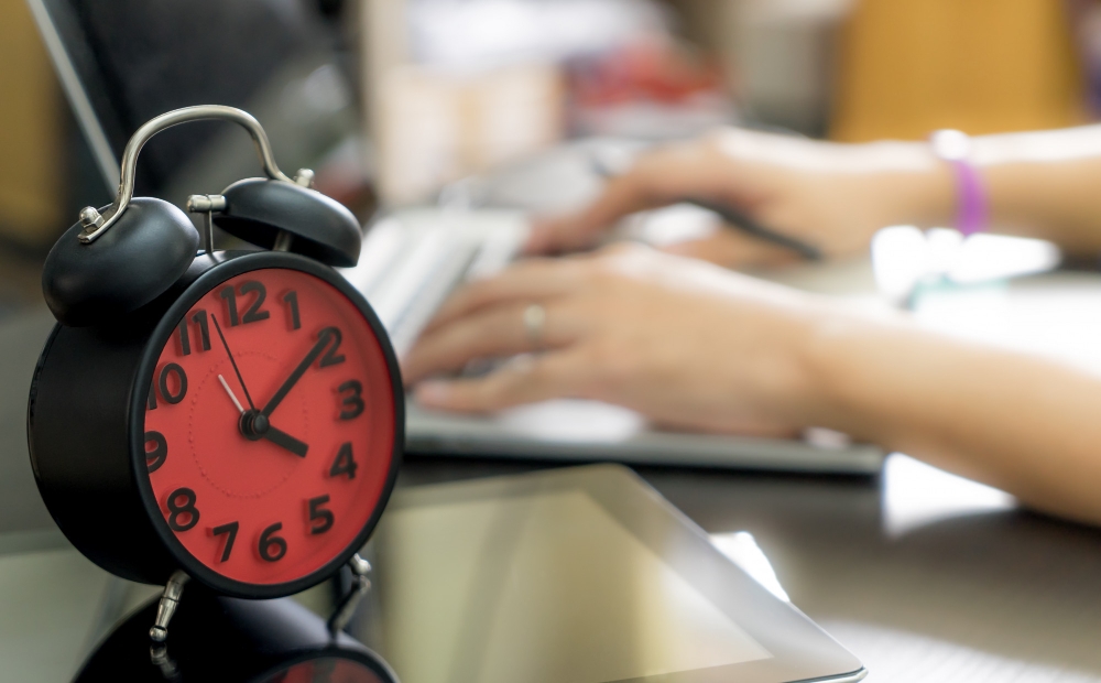 Office worker at desk late afternoon, showing long working hours in a year.