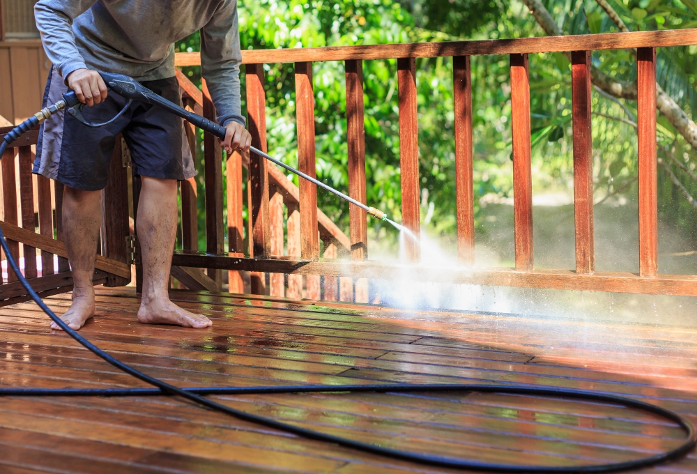 Worker pressure washing wooden floor, representing risks that require liability insurance coverage.
