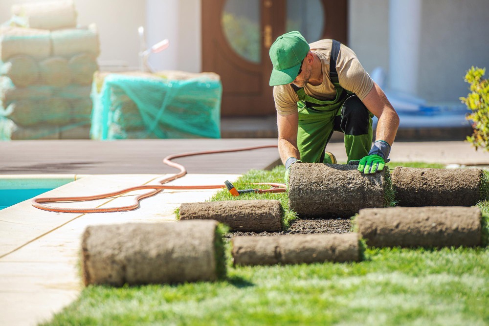 Landscaper laying down fresh rolls of grass
