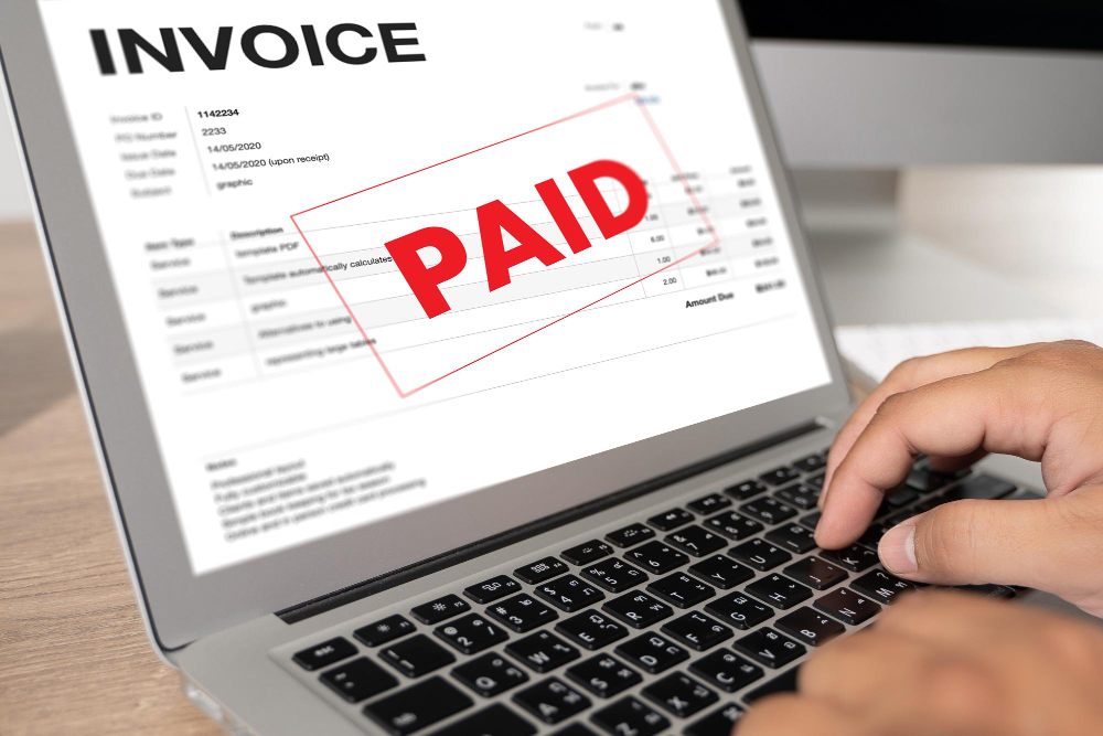 invoice marked paid on laptop screen