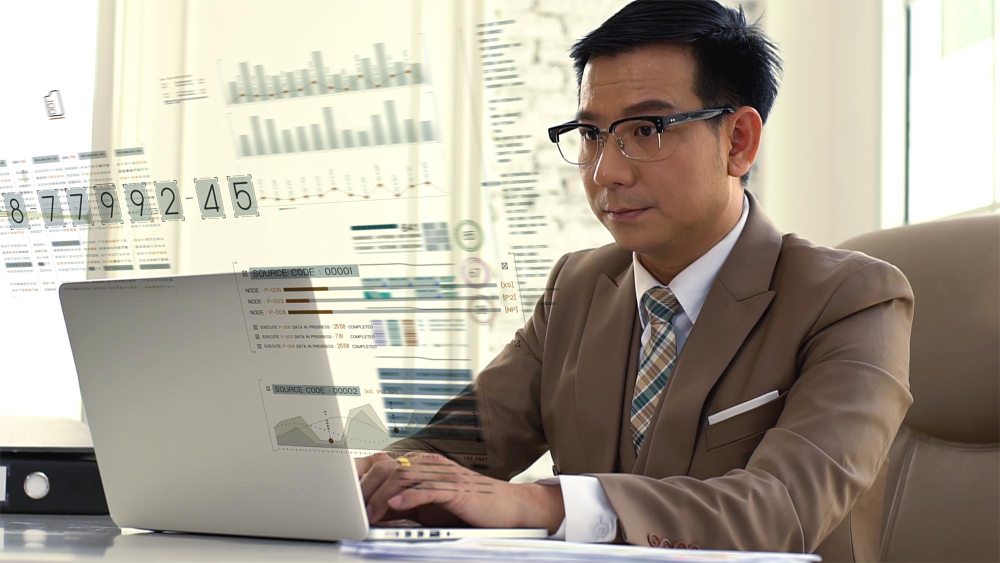 Businessman managing financial tasks on laptop in modern office