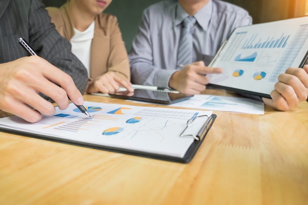 Business team collaborating on financial strategy at laptop table