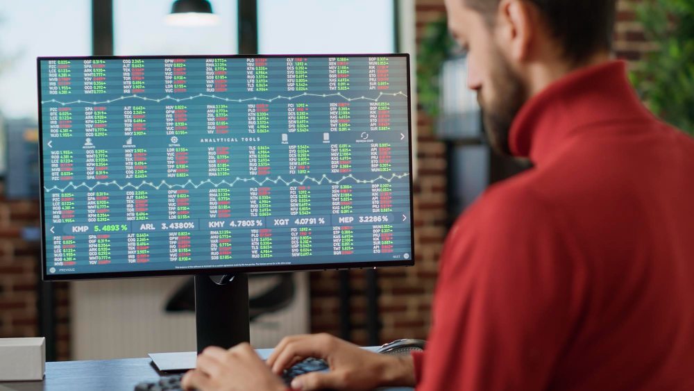 Analyst reviewing stock charts on computer screen