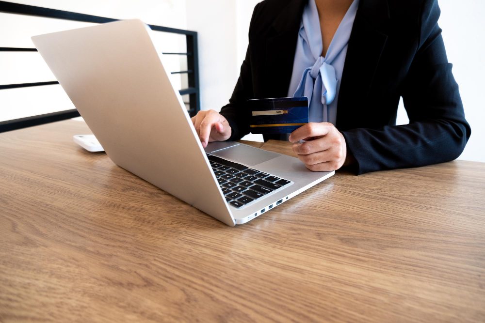 Business owner making online bank transfer on laptop