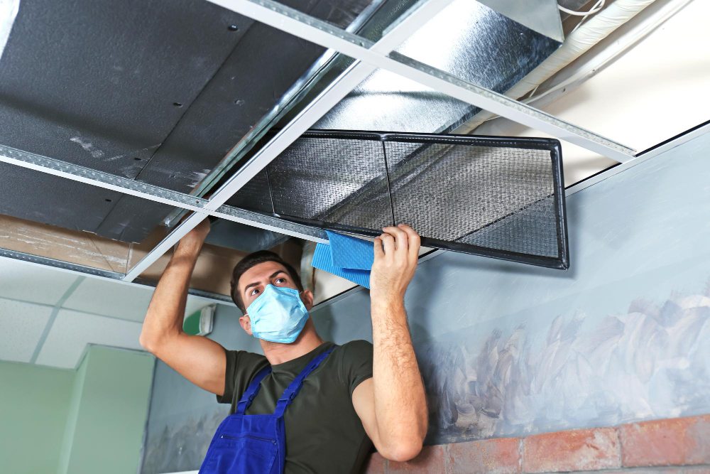 HVAC technician cleaning industrial air conditioning system