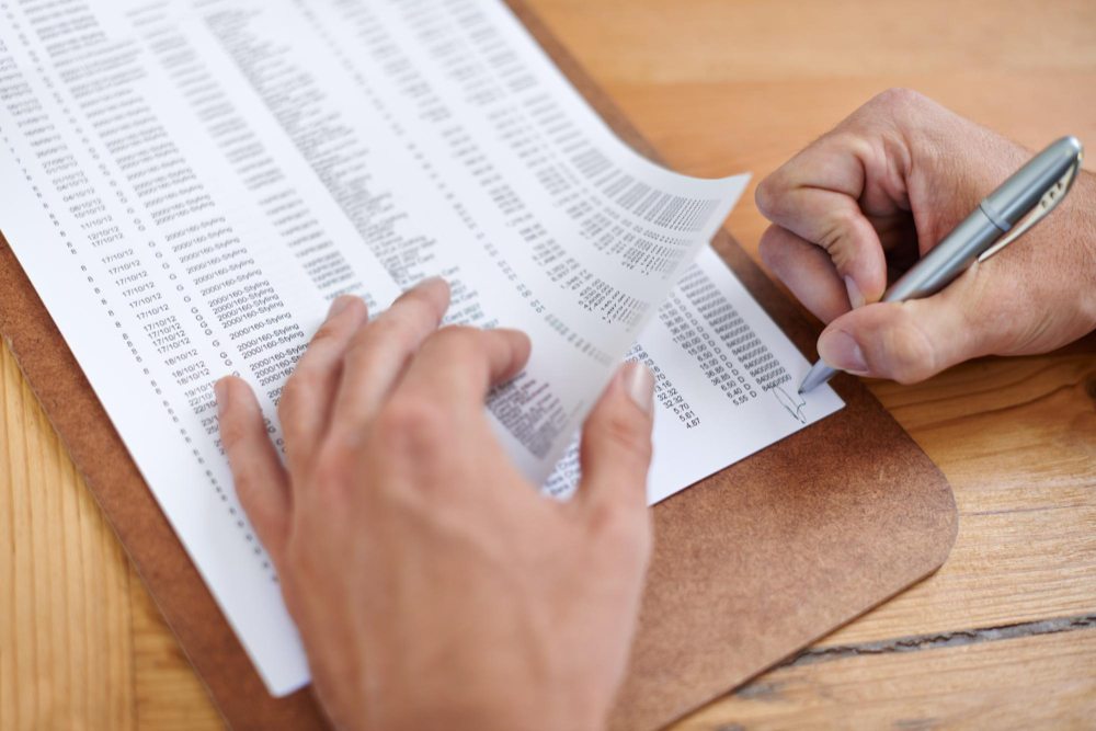 Business owner reviewing printed itemized invoice documents