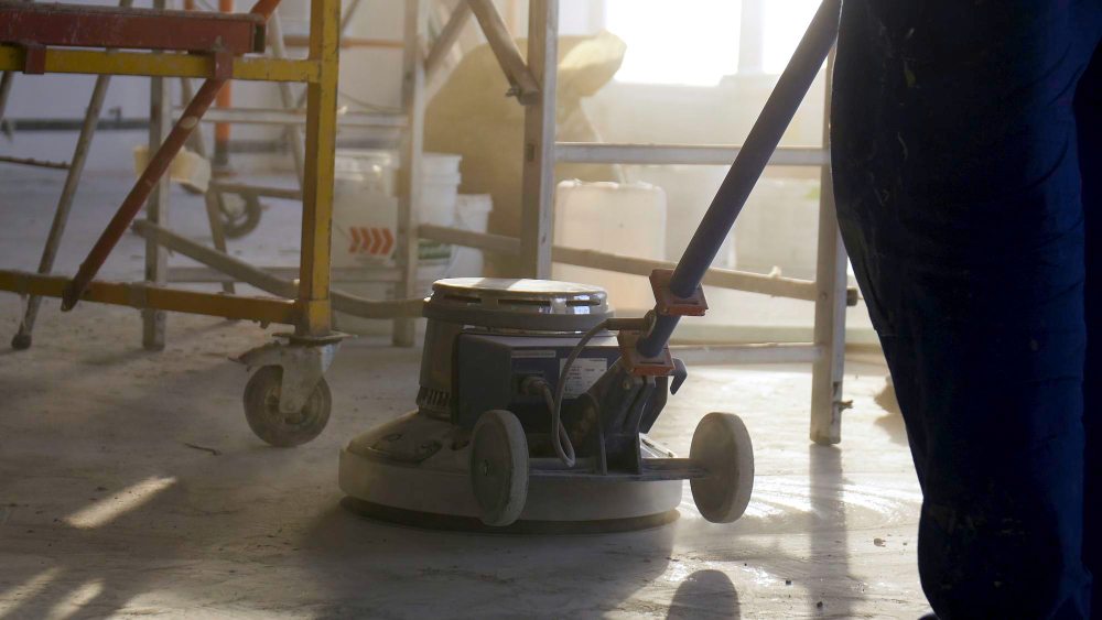 Technician polishing industrial concrete floor with machine
