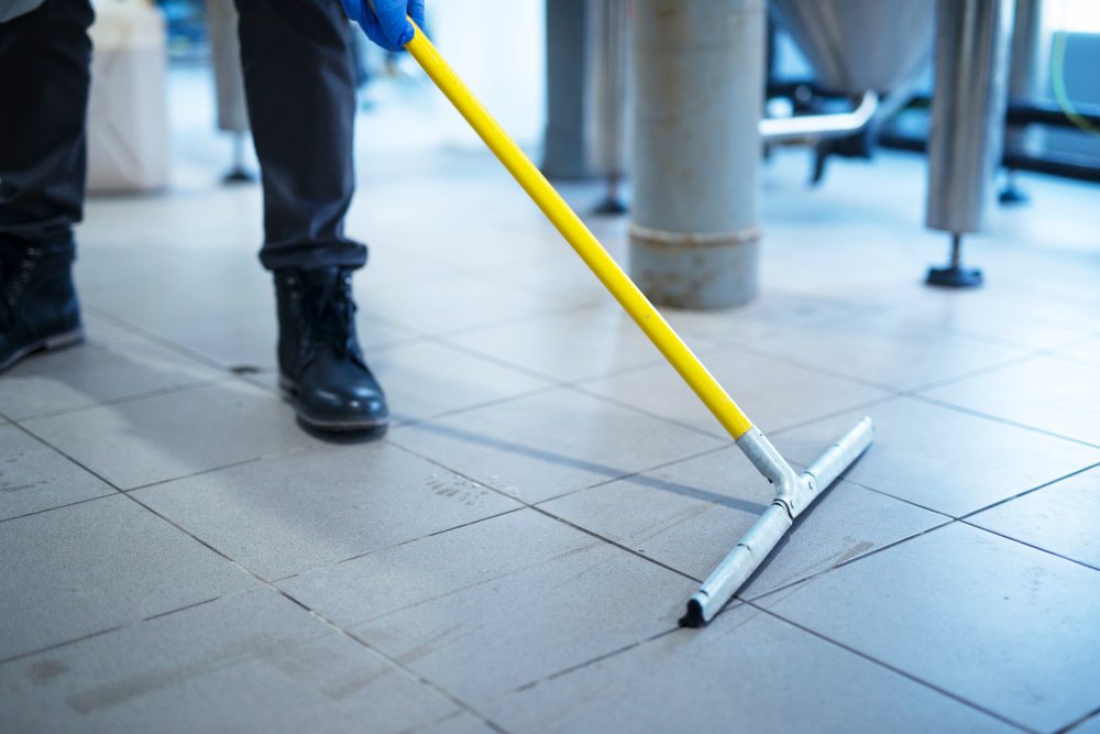 Worker mopping industrial facility floor