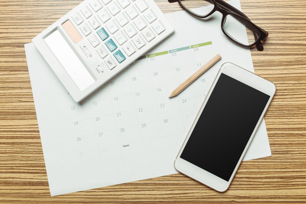 Office desk with calendar and smartphone for invoice planning