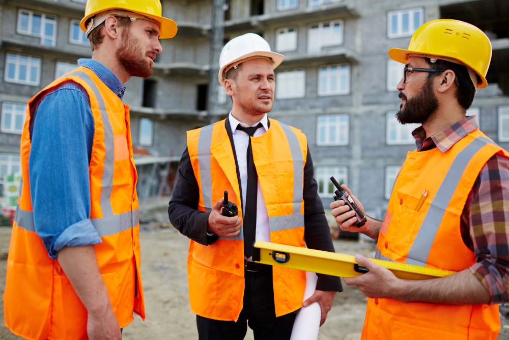 Construction contractor supervising workers on building site