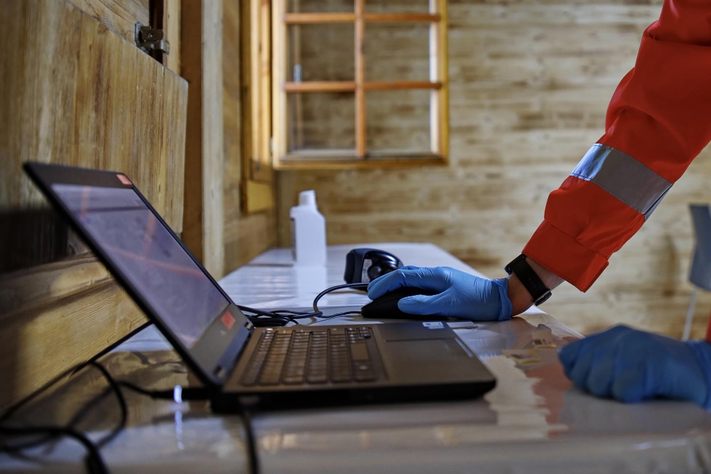 Pest control professional calculating inspection cost on laptop