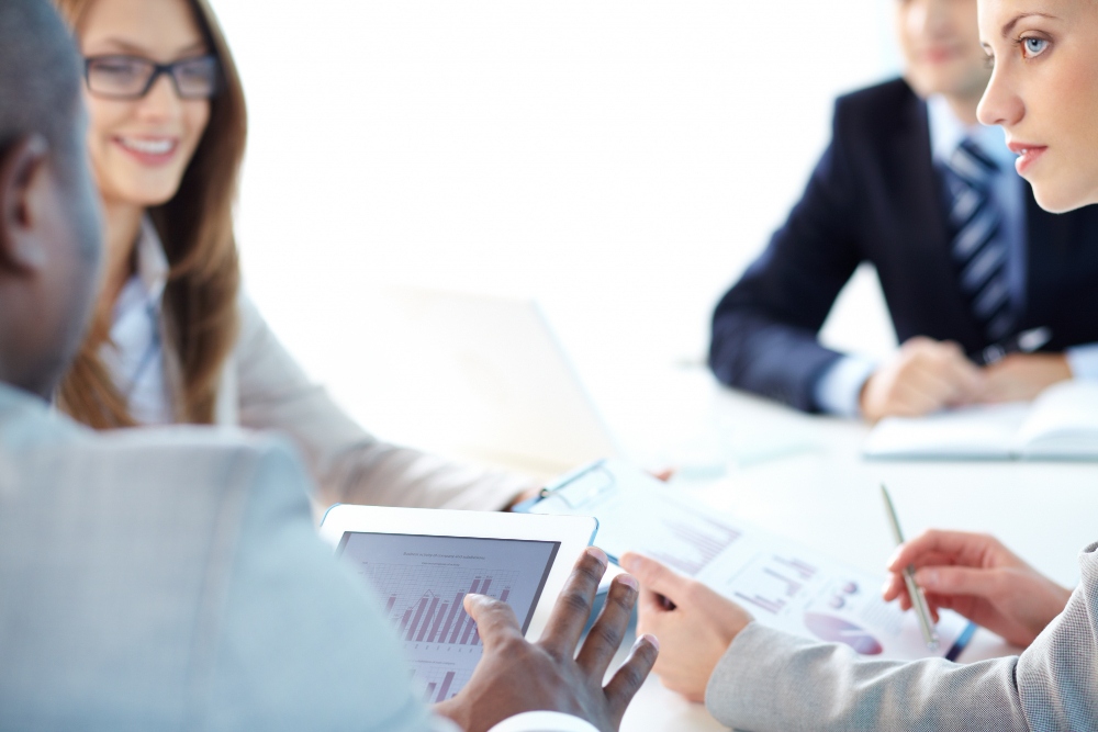 Los colegas debaten los informes financieros y la planificación de costes en una reunión de oficina