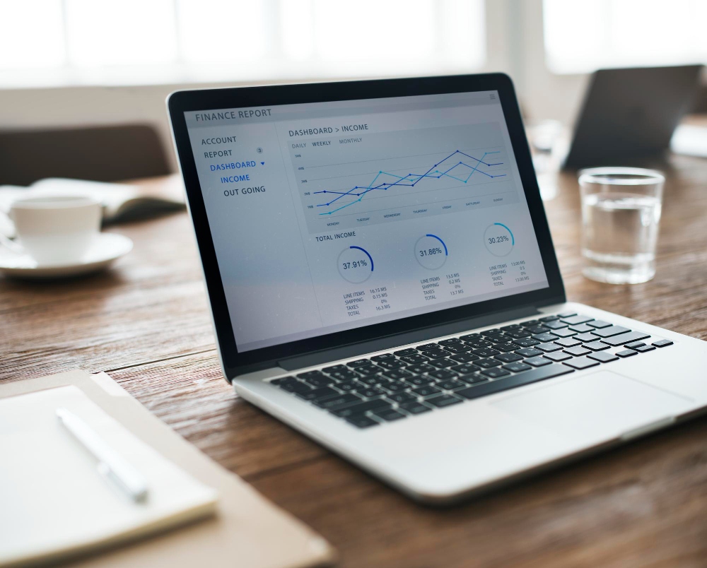 Moderno espacio de trabajo con un portátil que muestra un panel de análisis financiero