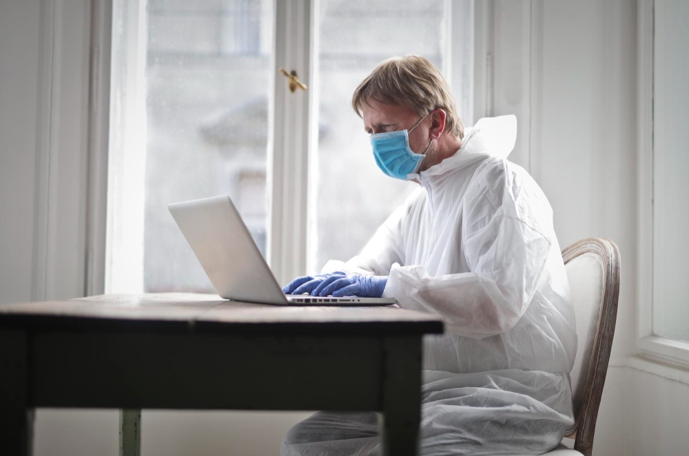 Pest control professional preparing inspection report on laptop