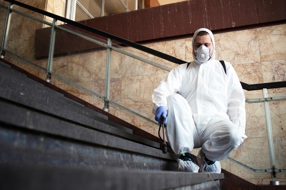 pest control technician inspecting property in protective suit
