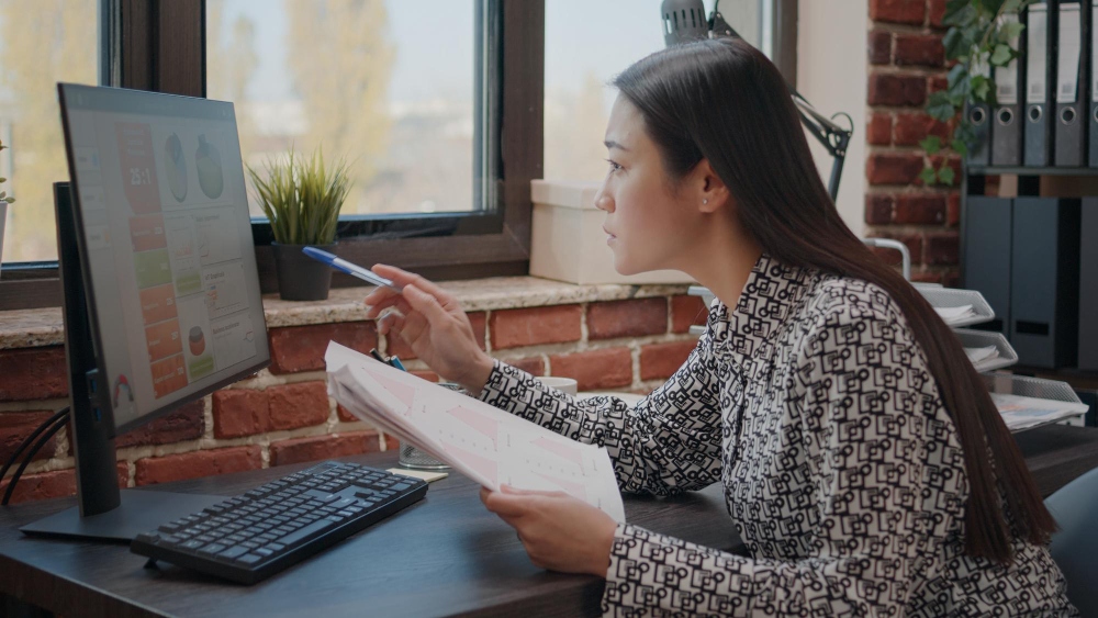 Person reviewing financial documents and bank statements on laptop