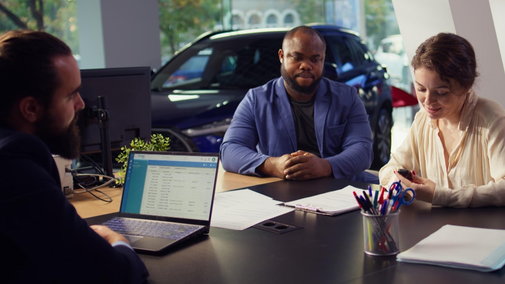 Un comprador de coches discute el precio de un vehículo con un vendedor del concesionario