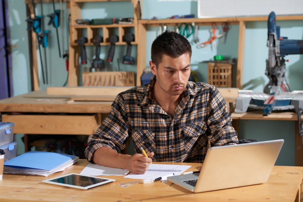 Pequeño empresario preparando un presupuesto en un taller