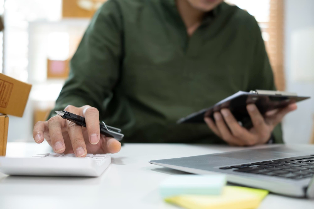 Persona que utiliza la calculadora para revisar los salarios y los gastos de la empresa