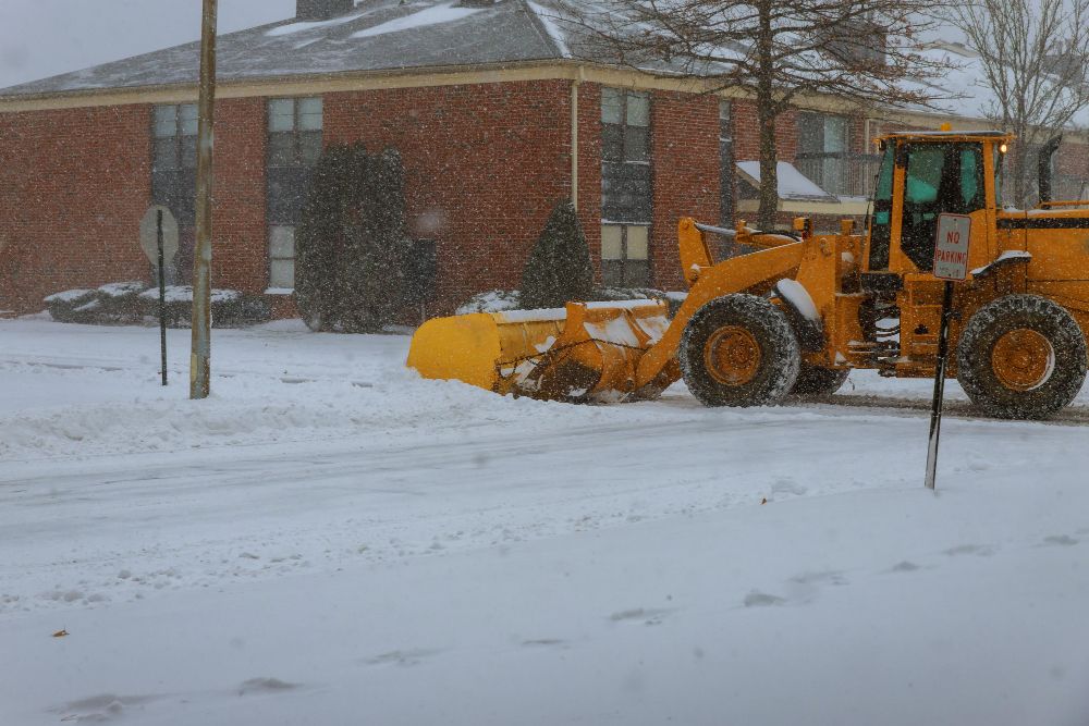 Snow removal truck clearing city streets during snowstorm