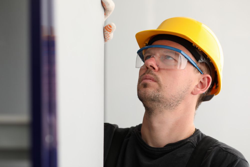 Contractor measuring wall during construction inspection