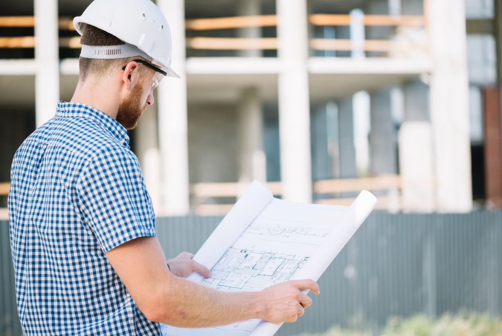 General contractor reviewing blueprints at construction site