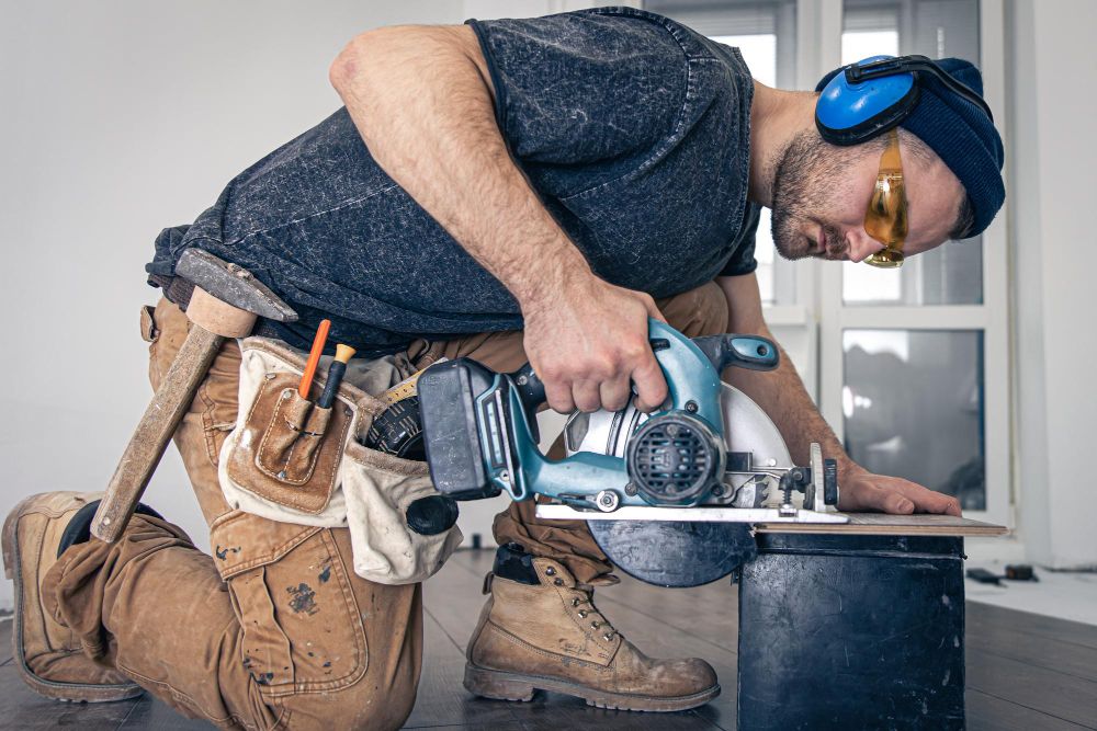 Carpenter using a circular saw with protective safety equipment