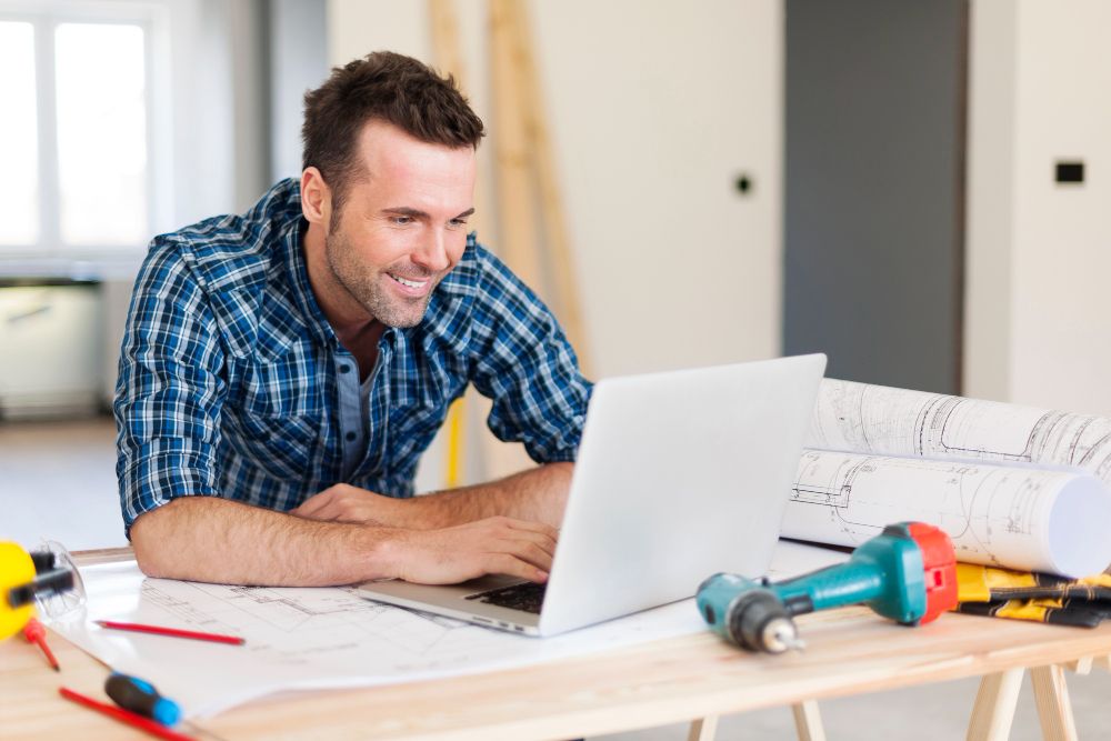 Construction worker using laptop for handyman business website management