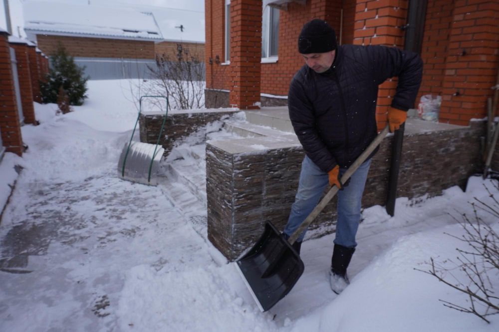 Homeowner clearing snow from residential property walkway