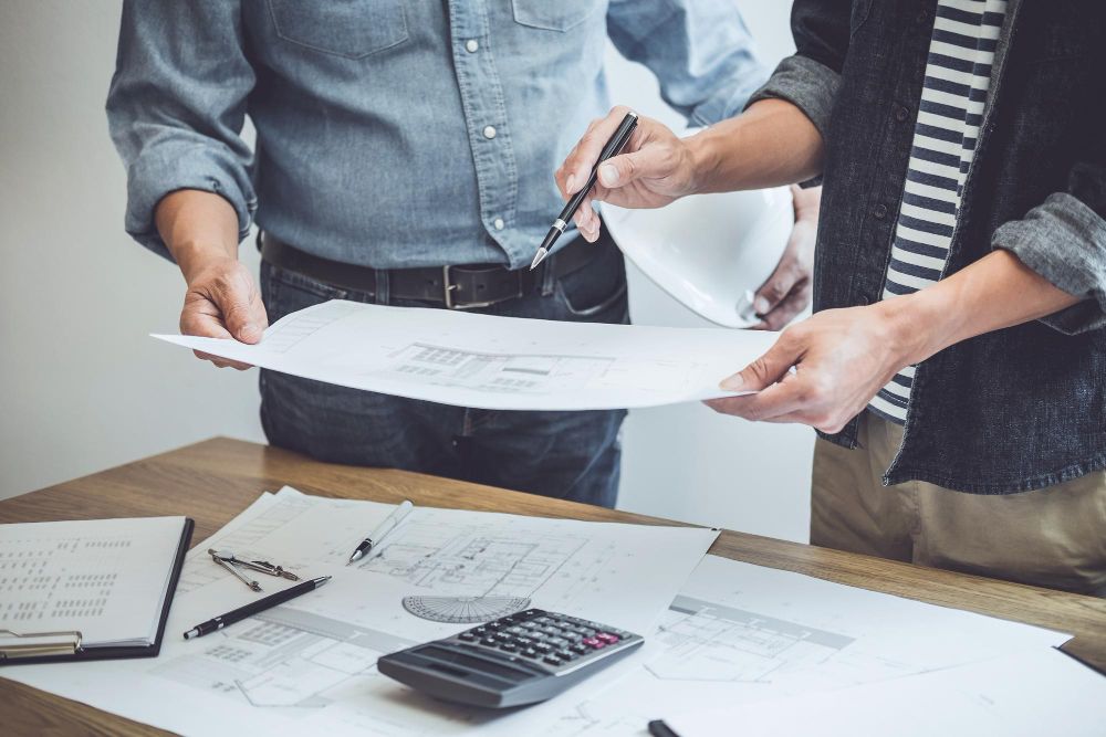 Contractor reviewing paperwork and roofing estimates at desk