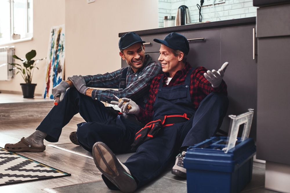 apprentice plumber assisting licensed plumber with bathroom plumbing repair