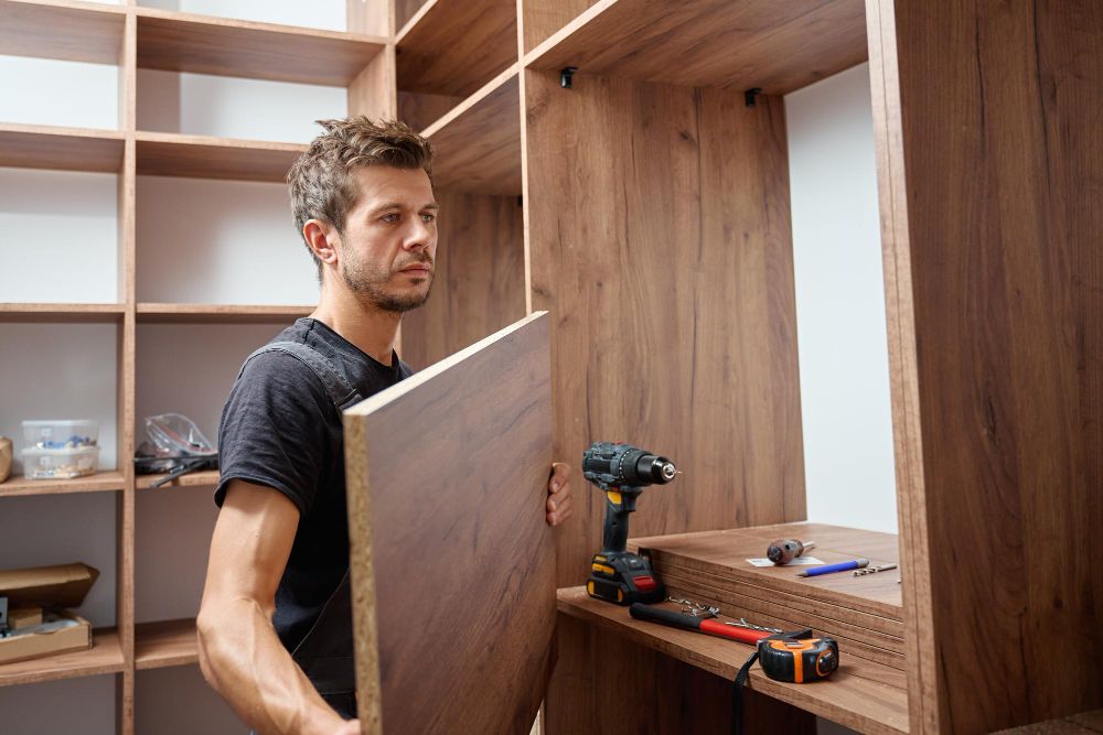 carpentry contractor measuring and installing custom built-in wood shelving