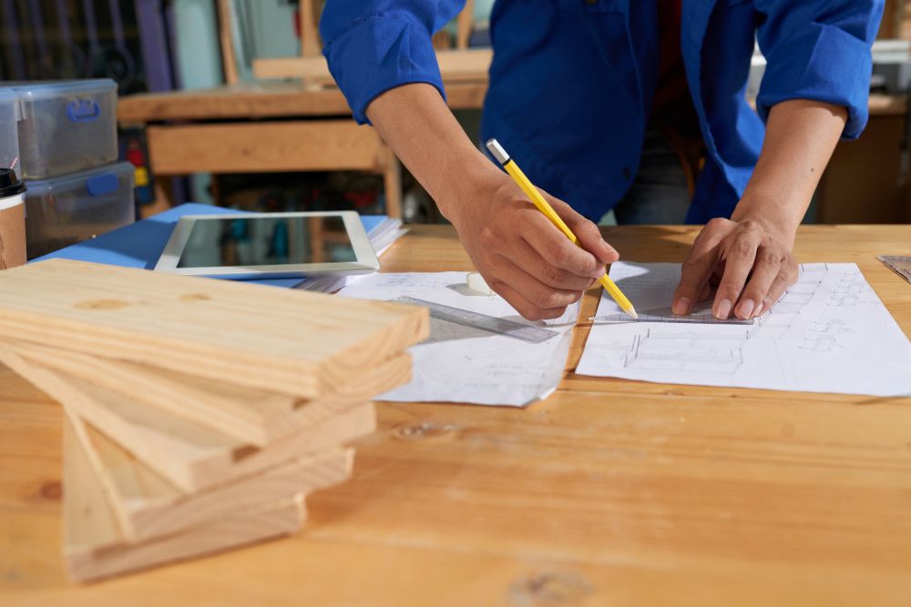 carpentry contractor reviewing blueprints and wood framing plans at job site
