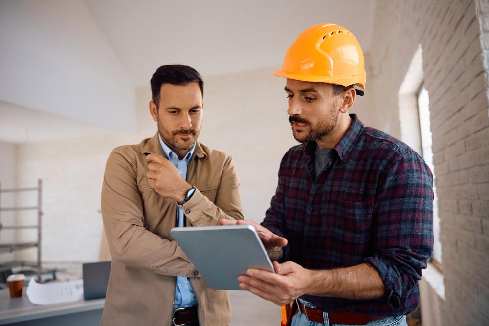 Contractor reviewing project details with a homeowner on a tablet